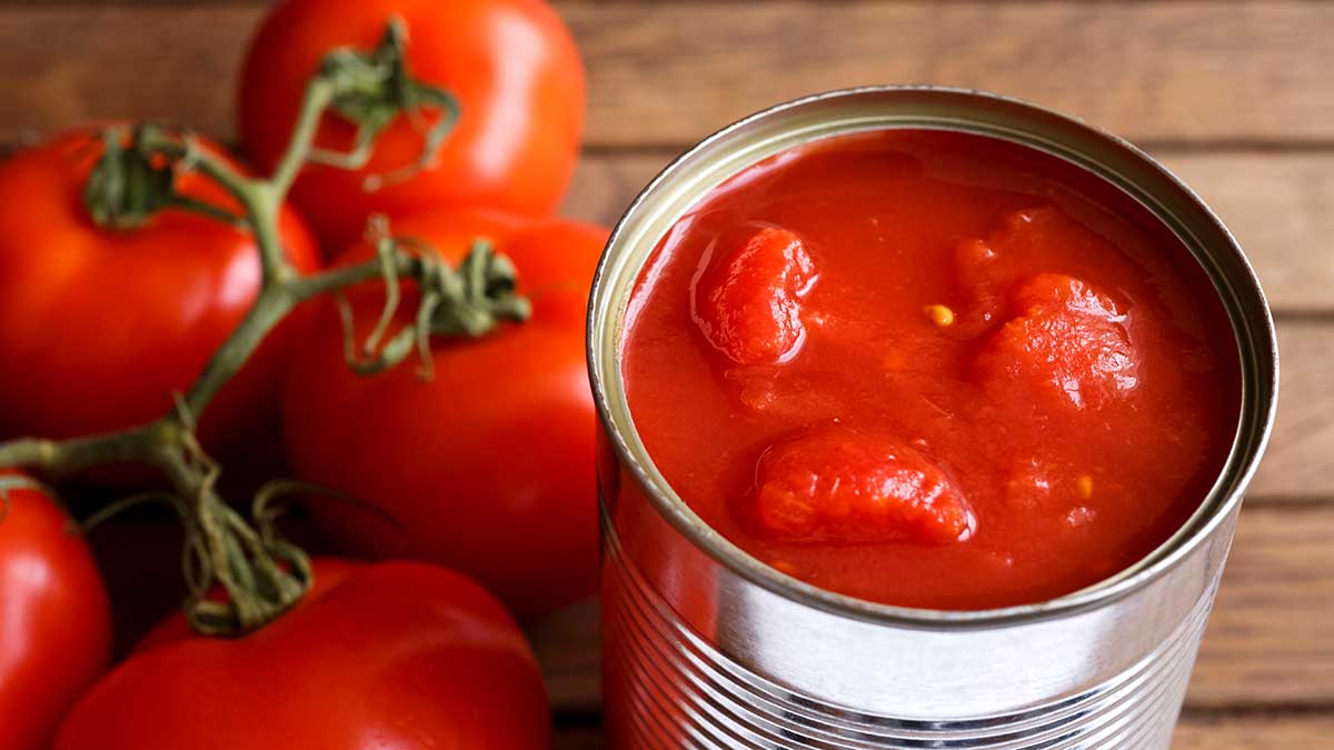 Plastik-Alternativen: Eine Konservendose mit Schältomaten, daneben frische Tomaten   