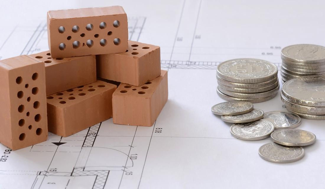 Münzen auf einem Bauplan