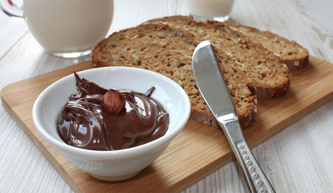 Schale mit Nutella und Brettchen mit geschnittenen Broten