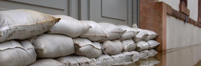 Überschwemmung und Sandsäcke an einer Tür