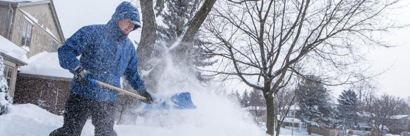 Mann beim Schnee schippen