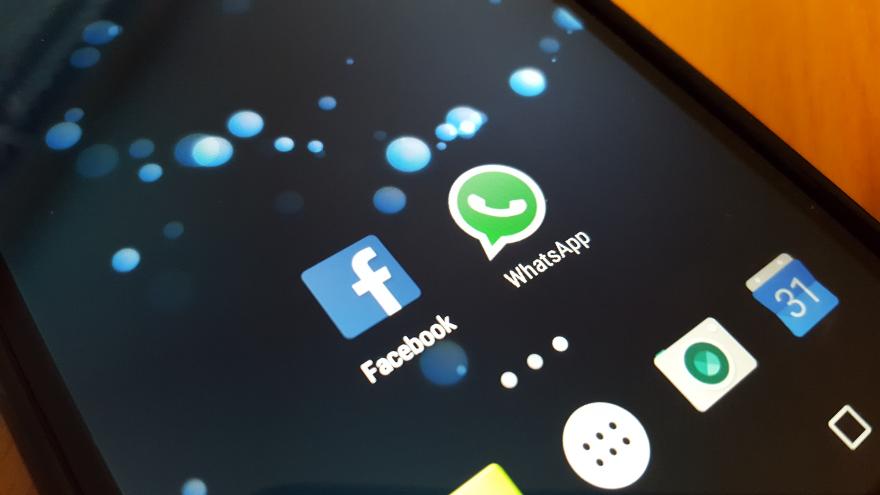 Smartphone mit Logos WhatsApp und Facebook
