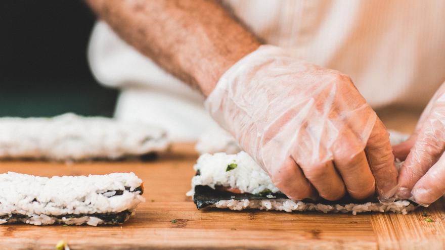 Hand, die Sushi zubereitet