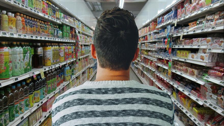 Mann im Supermarkt zwischen Regalen