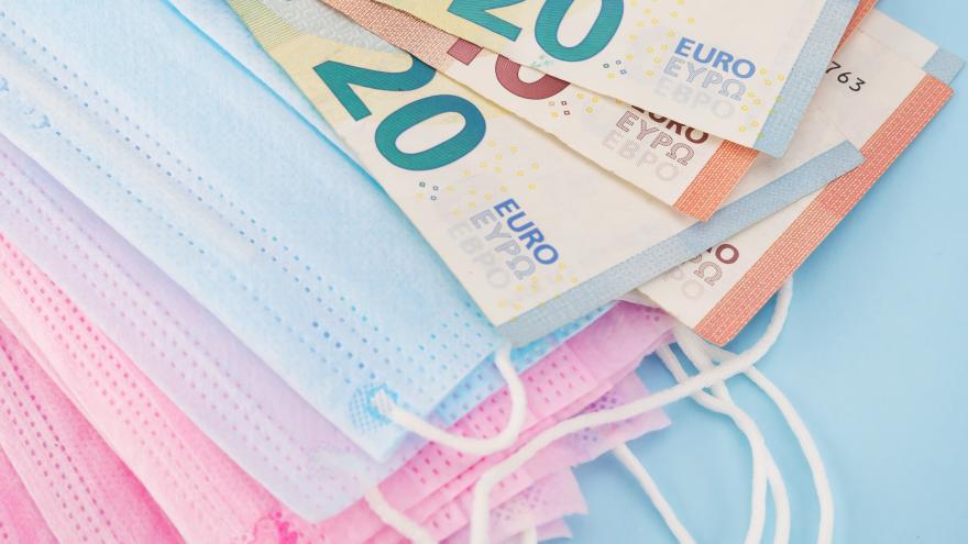 Euro scheine liegen neben Schutzmasken