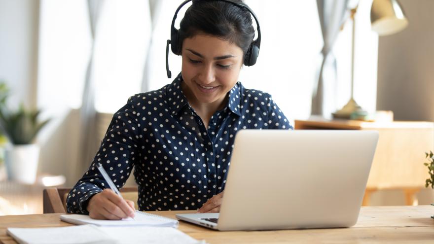 Frau nimmt mit ihrem Laptop an einem Webinar teil
