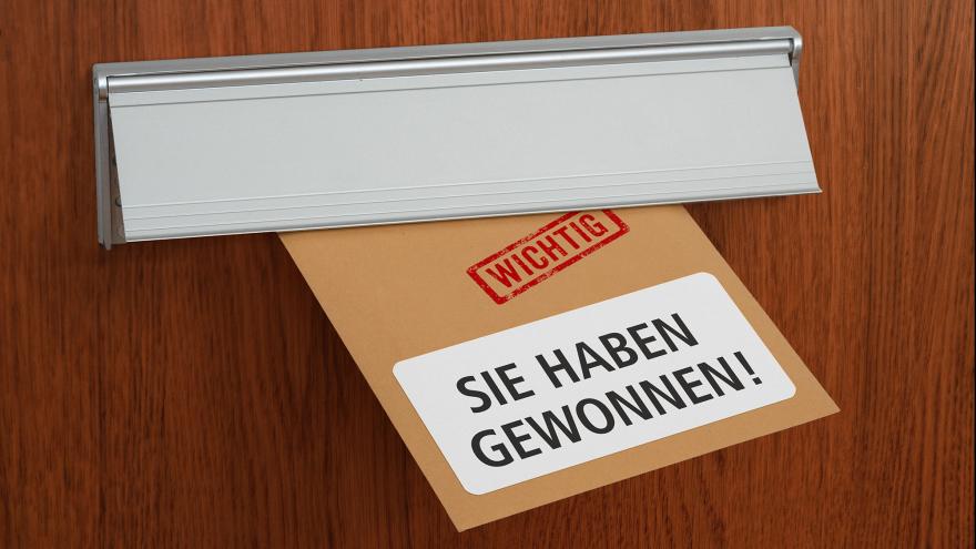 Brief mit der Aufschrift "Sie haben gewonnen!" ragt aus Briefschlitz