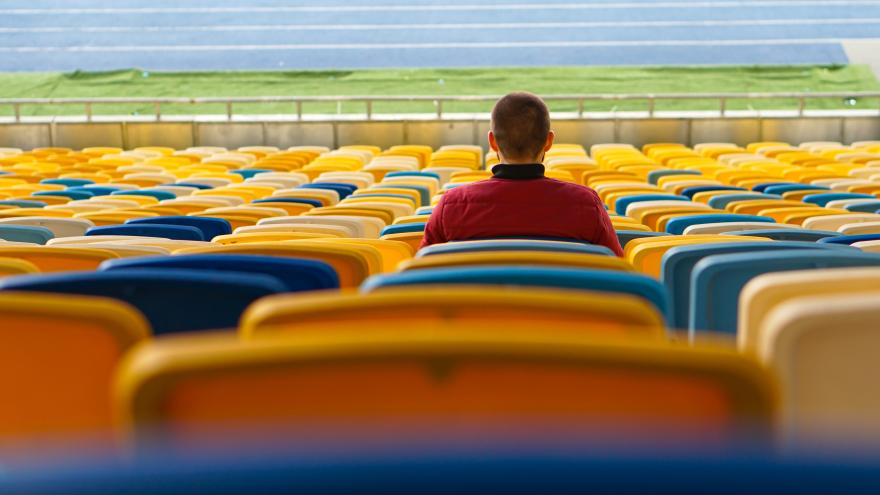 Mann sitzt in leerem Stadion