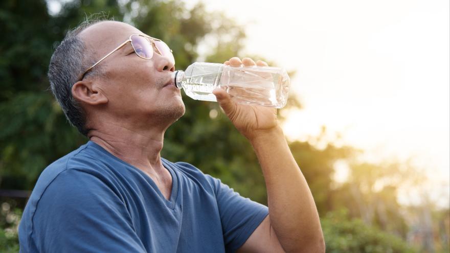 Älterer Mann trinkt aus einer Wasserflasche