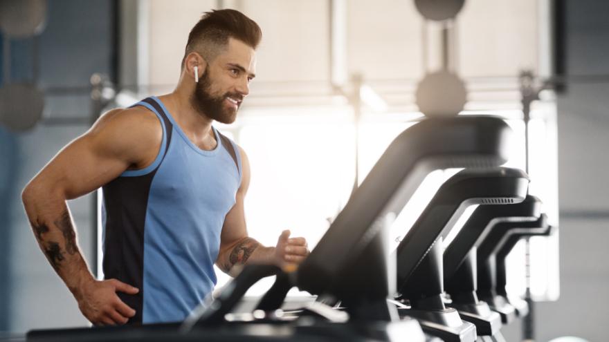 Ein Mann trainiert im Fitnessstudio auf einem Laufband