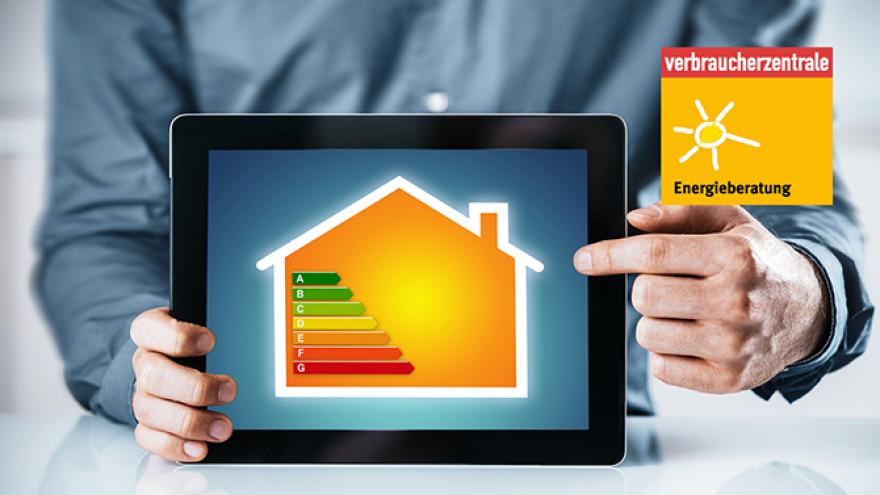 Mann deutet auf ein Tablet, das einer Energielabel in Form eines Hauses anzeigt