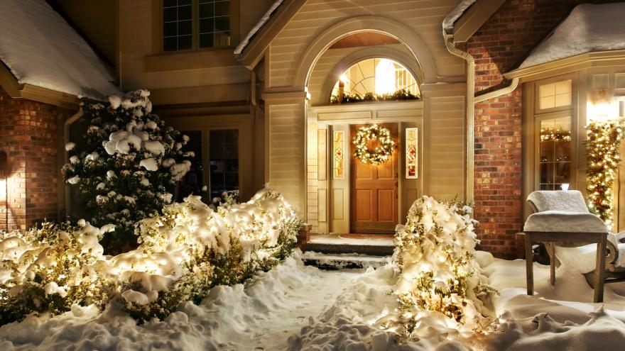 Schneebedeckter Hauseingang mit umfangreicher Weihnachtsbeleuchtung