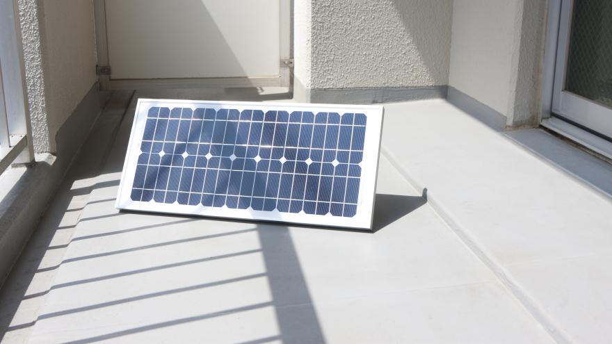 Einzelnes Solarpaneel für die Steckdose steht auf einen sonnigen Balkon