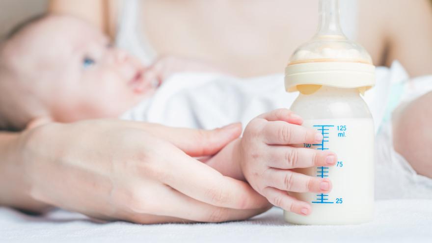 Baby hält ein Fläschchen mit Milch