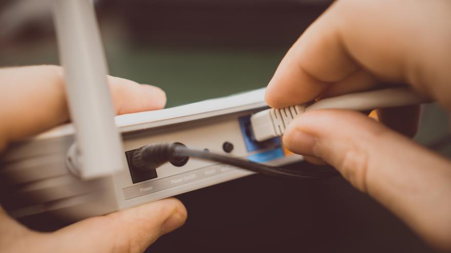Netzwerkkabel wird in einen Anschluss am Router eingesteckt