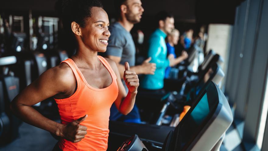 Frau benutzt ein Laufband im Fitnessstudio