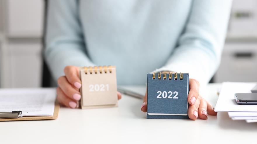 Frau präsentiert einen Tischkalender für 2022