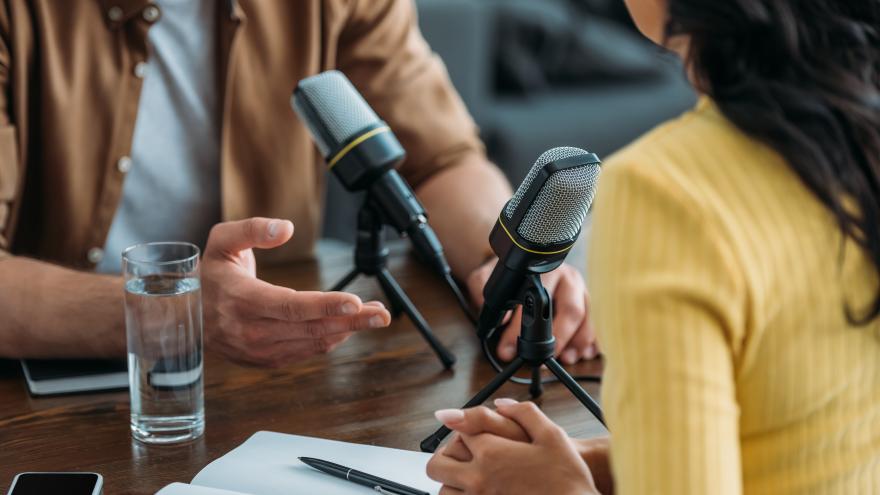 Mann und Frau gegenüber bei der Aufnahme eines Podcasts