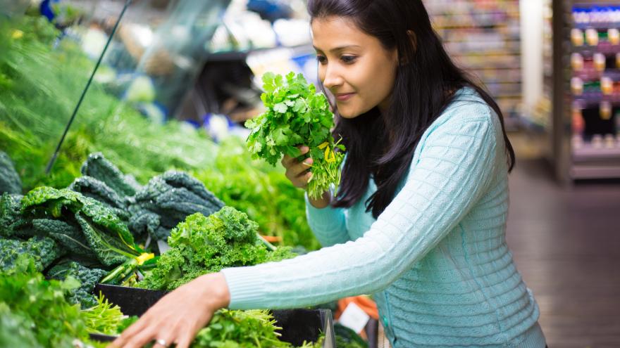 Frau beim Gemüseneinkauf im Supermarkt