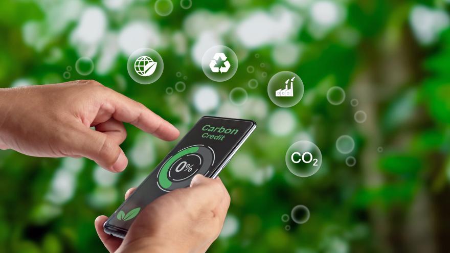 Hand bedient ein Smartphone mit Logos rund um das Thema Klimaschutz