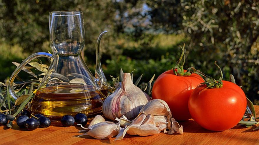 Gemüse und Olivenöl auf einem Tisch im Garten
