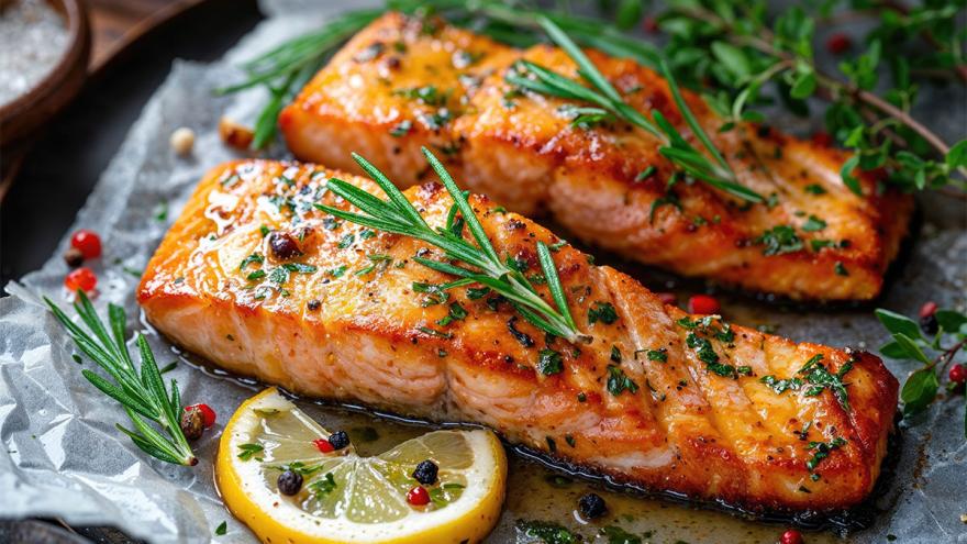 Gegrilltes Seelachsfilet und eine Zitronenscheibe mit KRäutern auf einem Teller angerichtet