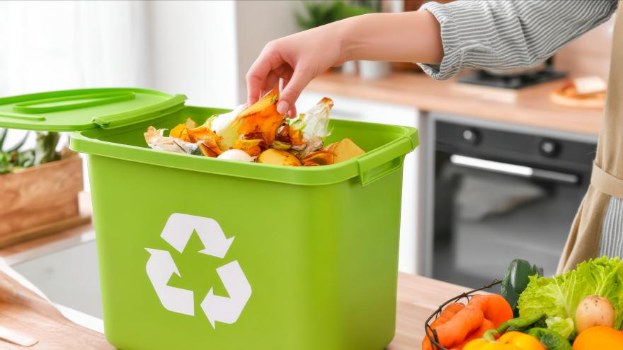 Biomüll wird in die Tonne geworfen.