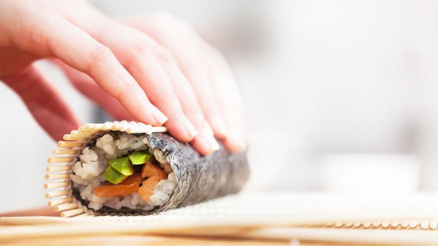 Hand rollt Sushi.