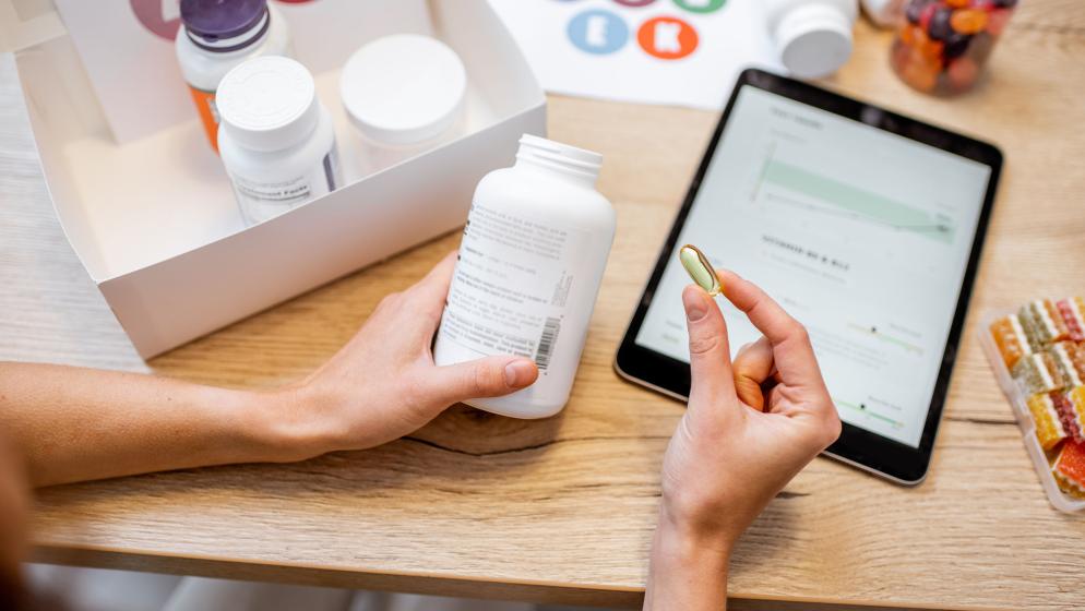 Hand hält eine Kapsel.