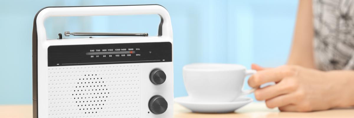 Frau neben Radio und Kaffeetasse