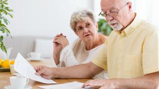 Älteres Ehepaar bei der Prüfung eines Pflegevertrags