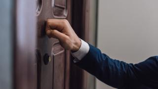 Vertreter klopft an eine Wohnungtür