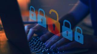 Montage eines geöffneten Schlosses vor einem Menschen, der einen Laptop benutzt