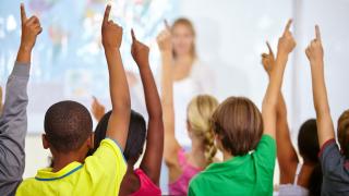 Kinder melden sich in der Schulklasse