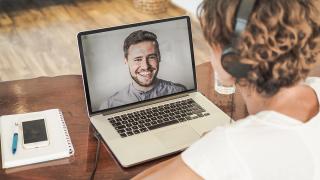 Frau nimmt per Laptop an einem Coaching teil