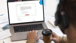 Person schaut online auf die Pauschalreisecheck-Seite