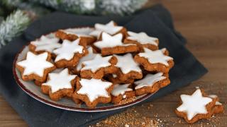 Zimsterne auf einem Teller und im Hintergrund liegt Tannengrün