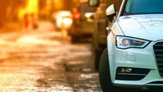 Foto eines an einer Straße geparkten Autos von vorne im Anschnitt