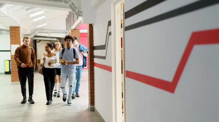 Schüler*innen im Teenager-Alter im Gang des Schulgebäudes